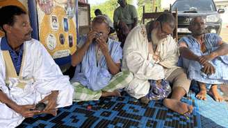 Caçadores nômades de meteoritos examinam as pedras que encontraram no deserto do Saara.
