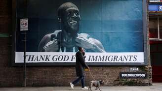 Uma pessoa passa por um outdoor com a imagem do rapper Stormzy, parte da campanha "Thank God For Immigrants" (Agradeça a Deus pelos Imigrantes) do grupo ativista Everyone Hates Elon, que celebra ícones imigrantes da cultura britânica, em Londres, Reino Unido, em 30 de outubro de 2025.