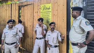 Policiais fazem guarda em frente à boate "Birch by Romeo Lane", onde um incêndio matou pelo menos 25 pessoas em 7 de dezembro de 2025, em Goa, na Índia.