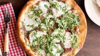 Pizza de presunto e burrata elaborada com azeite extra virgem siciliano, presunto de Parma, queijos cremosos e mussarela, coberta com rúcula fresca. Foto ilustrativa.