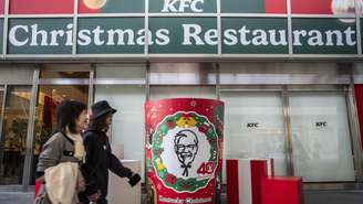 Japonesas passam pelo restaurante KFC em Tóquio, onde a tradição na noite de Natal é comer frango frito.