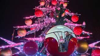 Pai e filha andam de carrossel em uma feira de Natal no centro de Kiev, em 21 de dezembro de 2025, apesar dos persistentes ataques russos na Ucrânia.