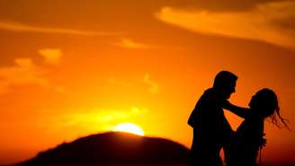 Casal posa ao nascer do sol na praia de Copacabana na véspera do Dia dos Namorados, no Rio de Janeiro.