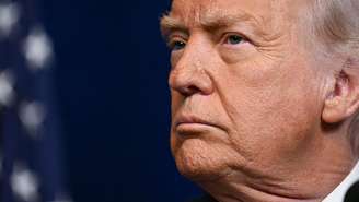 O presidente dos EUA, Donald Trump, observa enquanto o primeiro-ministro de Israel, Benjamin Netanyahu (fora do enquadramento), fala a jornalistas durante uma entrevista coletiva conjunta na residência de Trump, Mar-a-Lago, em Palm Beach (EUA), em 29/12/2025