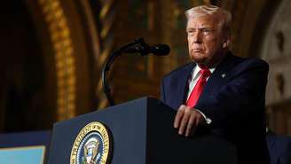 O presidente dos Estados Unidos, Donald Trump, em fala pública  em sua propriedade em Mar-a-Lago, em 22 de dezembro de 2025. Ele usa terno e gravata e olha de forma séria para a frente.