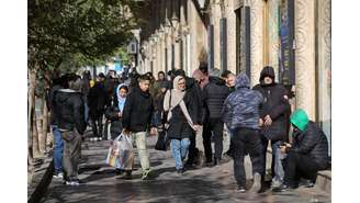 Pessoas passam por lojas em Teerã 30/12/2025
