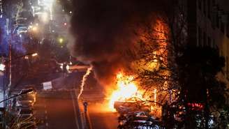 Carros em chamas em uma rua durante uma manifestação em Teerã, no Irã, em 8 de janeiro de 2026.