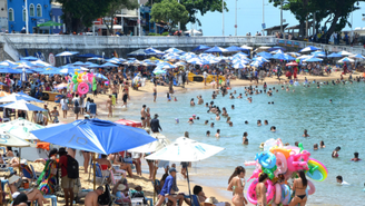 Banhistas aproveitam a praia do Porto da Barra em dia de calor, com temperatura em torno de 30°C, na manhã desta terça-feira (13).