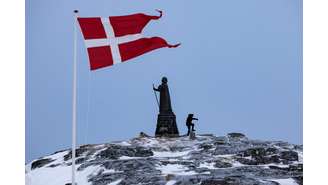 A bandeira dinamarquesa tremula ao lado da estátua de Hans Egede em Nuuk, Groenlândia, em 9 de março de 2025