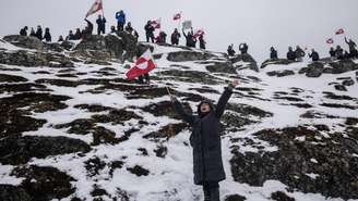 Pessoas participam de um protesto contra a exigência do presidente norte-americano Donald Trump de que a ilha do Ártico seja cedida aos Estados Unidos, defendendo que ela tenha o direito de decidir seu próprio futuro, em Nuuk, Groenlândia, 17 de janeiro de 2026.