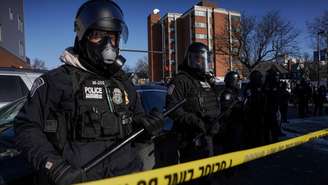 Policiais fazem guarda no local de um tiroteio envolvendo agentes federais de imigração no bairro Whittier, no sul de Minneapolis, Minnesota, EUA, em 24 de janeiro de 2026
