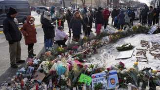 Pessoas reunidas em frente a um memorial improvisado no local onde Alex Pretti foi morto por agentes federais que tentavam prendê-lo, em Minneapolis, em 25 de janeiro de 2026.