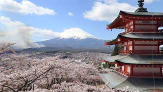 Flores de cerejeira em volta de um pagode no parque Arakurayama Sengen em Fujiyoshida, no Japão, com o monte Fuji ao fundo
