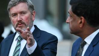 Os parlamentares Thomas Massie (à esquerda), republicano do Kentucky, et Ro Khanna, democrata da Califórnia falam a jornalistas na frente do ministério da Justiça, em Washington, em 9 de fevereiro de 2026.