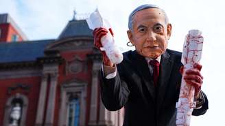 Uma pessoa usando uma máscara representando o primeiro-ministro israelense participa de um protesto no dia em que o presidente dos EUA, Donald Trump, se encontra com Netanyahu, em Washington, em 11 de fevereiro de 2026.