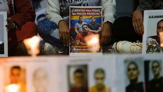 Pessoas exibem cartazes durante uma vigília exigindo a libertação de presos políticos em frente ao edifício El Helicoide, sede do Serviço Bolivariano de Inteligência Nacional (SEBIN), em Caracas, em 21 de fevereiro de 2026.