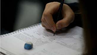 Aluno faz anotação em sala de aula