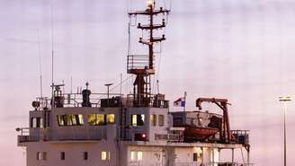 Foto mostra o navio cargueiro Mikhail Dudin atracado no porto de Dunquerque enquanto ativistas do Greenpeace participam de uma operação para bloqueá-lo, em 2 de março de 2026.