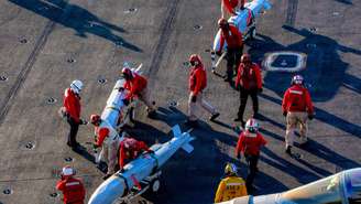 Marinheiros americanos movimentam munições no convés de voo do porta‑aviões USS Abraham Lincoln (CVN‑72), da classe Nimitz, durante a Operação Fúria Épica, em 28 de fevereiro de 2026.