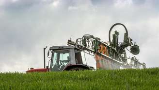 Um agricultor francês espalha fertilizante em uma lavoura de trigo. Imagem ilustrativa