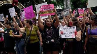 Grupo de mulheres levantando cartazes durante manifestação contra o feminicídio em dezembro de 2025.