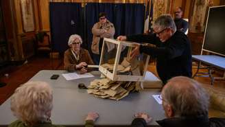 Funcionários esvaziam uma urna após o encerramento das seções eleitorais durante as eleições municipais para a prefeitura de Perpignan, no sudoeste da França, em 15 de março de 2026.