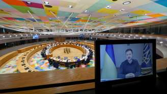 O presidente da Ucrânia, Volodymyr Zelenskiy, discursa para líderes da UE por videoconferência durante uma mesa redonda na cúpula da UE em Bruxelas, Bélgica. Em 19 de março de 2026.