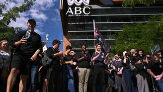 Jornalistas e funcionários em greve se reúnem em frente à sede da Australian Broadcasting Corporation (ABC). Eles exigem melhores salários e proteções para impedir que a inteligência artificial tome seus empregos. Em Melbourne, em 25 de março de 2026.