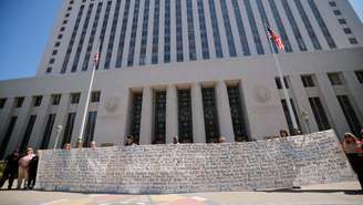 Pais seguram uma faixa com os nomes das crianças do lado de fora do tribunal que julgou uma ação sobre responsabilidade dad plataformas sobre vício de menores nas redes sociais, em Los Angeles, Califórnia, EUA, em 25 de março de 2026.