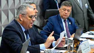 Alfredo Gaspar durante leitura de trecho do parecer, observado por Carlos Viana