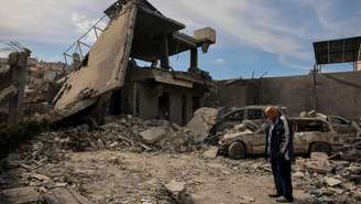 Um morador de pé próximo a um prédio destruído por um ataque israelense, em Saksakiyeh, no sul do Líbano, em 28 de março de 2026.