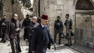 Policiais israelenses acompanham um grupo de frades franciscanos que caminham pela Via Crucis nesta Sexta-feira Santa, 3 de abril de 2026, na Cidade Velha de Jerusalém.