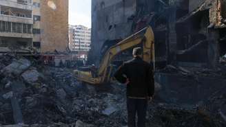 Um homem observa uma retroescavadeira em funcionamento no local de um ataque israelense realizado na quarta-feira (8) em Al-Mazraa, Beirute, Líbano. Em 9 de abril de 2026.