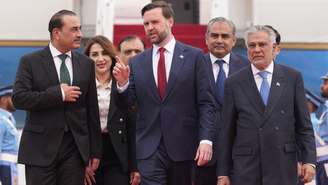 O vice‑presidente dos Estados Unidos, JD Vance (centro), caminha entre o chefe das Forças Armadas paquistanesas, Asim Munir, e do vice‑primeiro‑ministro e ministro das Relações Exteriores paquistanês, Mohammad Ishaq Dar, após desembarcar em Islamabad, neste sábado, 11 de abril de 2026.