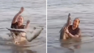 Mulher segura jacaré por engano em lagoa