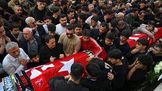 Familiares e amigos ao lado do caixão de Bayram Nabi Şişik, de 10 anos, durante os funerais das nove vítimas mortas em um tiroteio em uma escola cometido por um jovem de 14 anos. O ataque chocou o país. Em Kahramanmaras, em 16 de abril de 2026.
