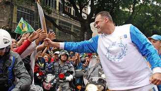 (ARQUIVO) Oscar Schmidt entrega a tocha olímpica a torcedores brasileiros durante uma cerimônia nas ruas do Rio de Janeiro, Brasil, em 13 de junho de 2004. O lendário jogador de basquete brasileiro morreu em 17 de abril de 2026, aos 68 anos, conforme anunciado pela Confederação Brasileira de Basquete (CBB) e sua família.