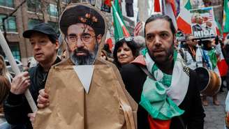 Um manifestante segura uma imagem do novo líder supremo do Irã, Mojtaba Khamenei, durante um protesto contra o governo iraniano, em Manhattan, Nova York, Estados Unidos, 15 de março de 2026.