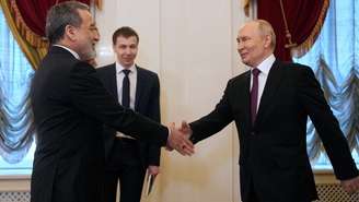 O presidente russo Vladimir Putin aperta a mão do ministro das Relações Exteriores do Irã, Abbas Araghchi, durante encontro na Biblioteca Presidencial Boris Yeltsin, em São Petersburgo, em 27 de abril de 2026.