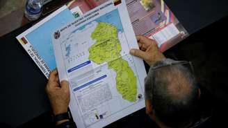 Imagem de arquivo. Um membro da Assembleia Nacional da Venezuela segura um mapa que mostra a região disputada de Essequibo como parte do país em meio ao aumento das tensões entre Caracas e a Guiana, às vésperas de um referendo sobre o território, em 6 de dezembro de 2023.