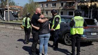Moradores reagem ao lado de um carro com o corpo de um parente morto por um ataque de míssil russo na cidade de Merefa, em meio ao ataque da Rússia à Ucrânia, na região de Kharkiv, Ucrânia, em 4 de maio de 2026.