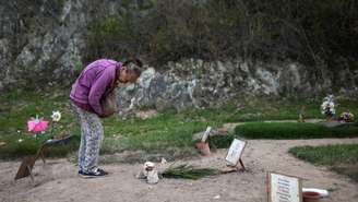 Carmen Navas, 82, junto ao túmulo do filho, Víctor Quero, detido e dado como morto pelas autoridades venezuelanas após mais de um ano de buscas, em cemitério de Caracas, em 7 de maio de 2026.