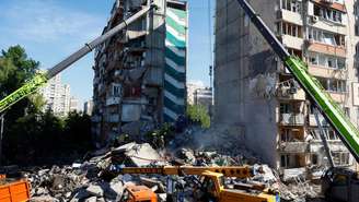 Equipes de resgate trabalham no local de um prédio residencial danificado durante ataques com mísseis e drones russos, no contexto da ofensiva da Rússia contra a Ucrânia, em Kiev, em 14 de maio de 2026.