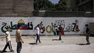 Jovens palestinos jogam futebol em Hebron, na Cisjordânia ocupada, ao lado de um mural em homenagem ao 78º aniversário da Nakba. (Imagem ilustrativa)