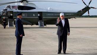 O presidente norte-americano Donald Trump cumprimenta a multidão após desembarcar do Air Force One em 15 de maio de 2026 na Base Aérea Conjunta Andrews, em Maryland.