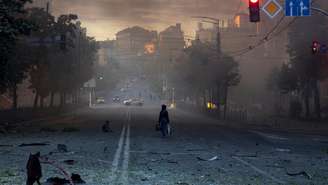 Uma mulher caminha por uma rua coberta de destroços após um ataque noturno russo com mísseis e drones, em meio à ofensiva da Rússia contra a Ucrânia, em Kiev, Ucrânia, em 24 de maio de 2026.