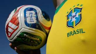 Pessoa com a camisa oficial da seleção brasileira segurando a bola oficial da Copa do Mundo de 2026