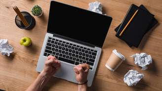 Homem reclama com notebook travado enquanto tenta concluir tarefa urgente em home office – depositphotos.com / tenedos