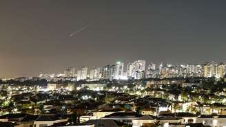 Um rastro de luz ilumina o céu durante um ataque de míssil do Irã em direção a Israel, visto de Ashkelon, Israel, em 7 de junho de 2026.