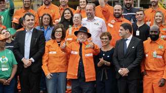 O presidente Luiz Inácio Lula da Silva (de chapéu) posa ao lado da presidente da Petrobras, Magda Chambriard (centro-esquerda), políticos e funcionários em um evento realizado para anunciar os investimentos da Petrobras na refinaria Gabriel Passos em Betim, Minas Gerais, Brasil, em 20 de março de 2026.